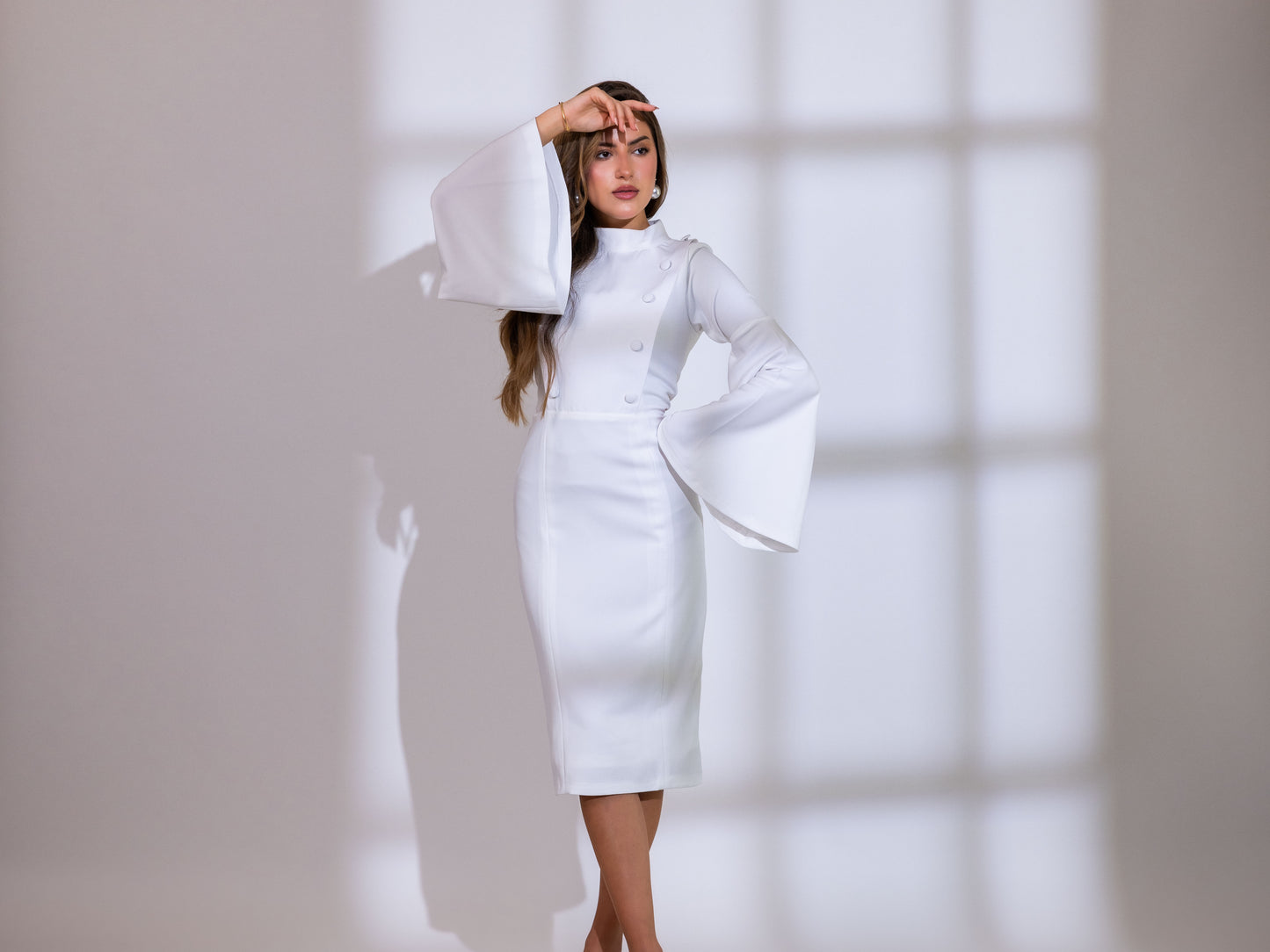 فستان أبيض مخروطي الشكل بأكمام جرس
